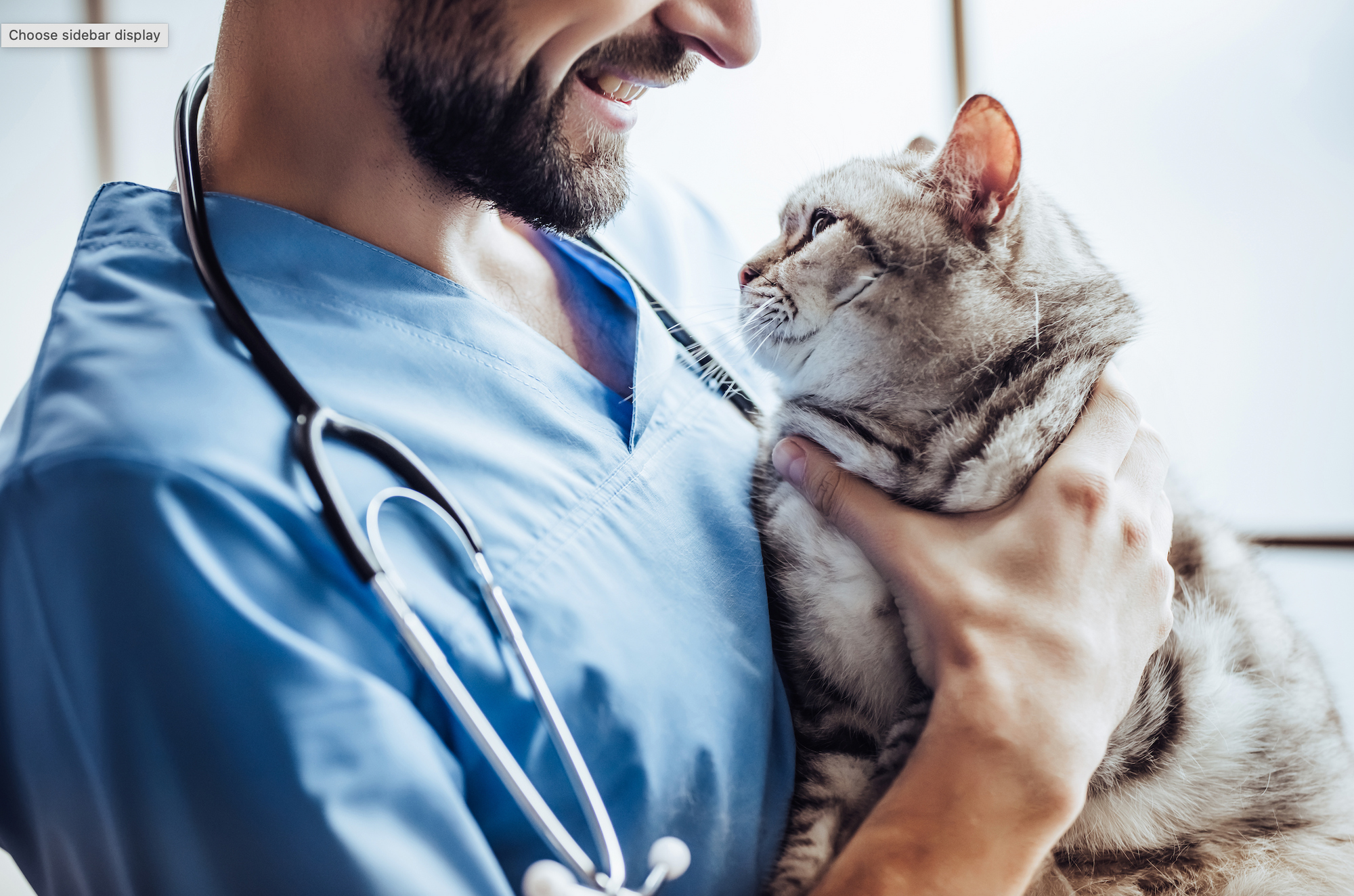 A man holding a cat with a stethoscope.